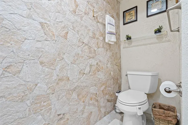a white toilet sitting next to a white wall