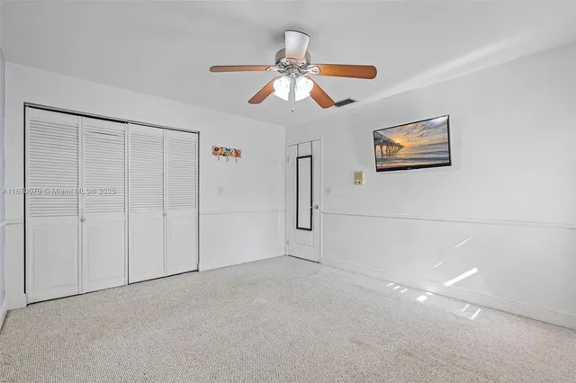 en empty room with window and ceiling fan