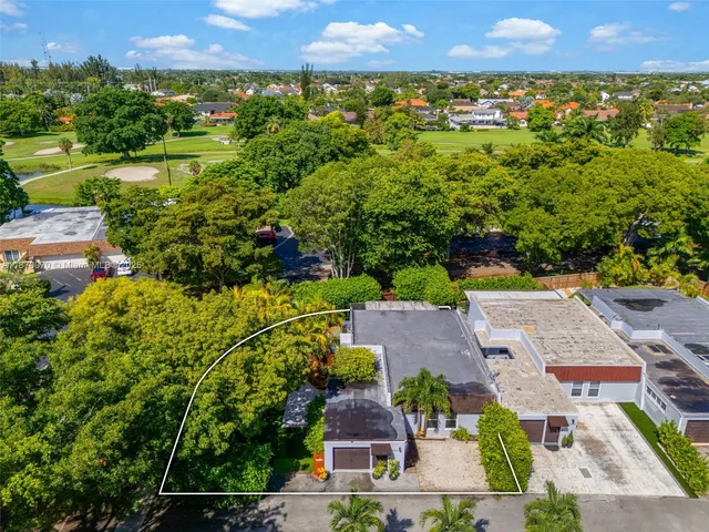 an aerial view of a house with garden space and a street view