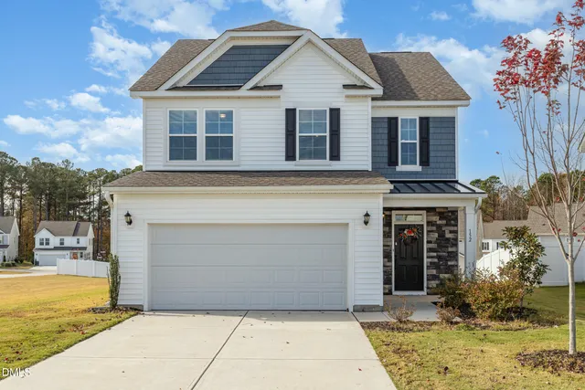 a front view of a house with a yard and garage