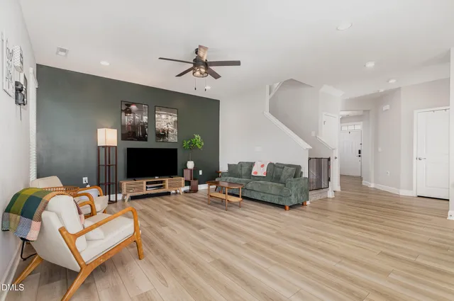 a living room with furniture and a wooden floor