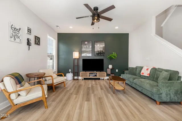 a living room with furniture and a wooden floor