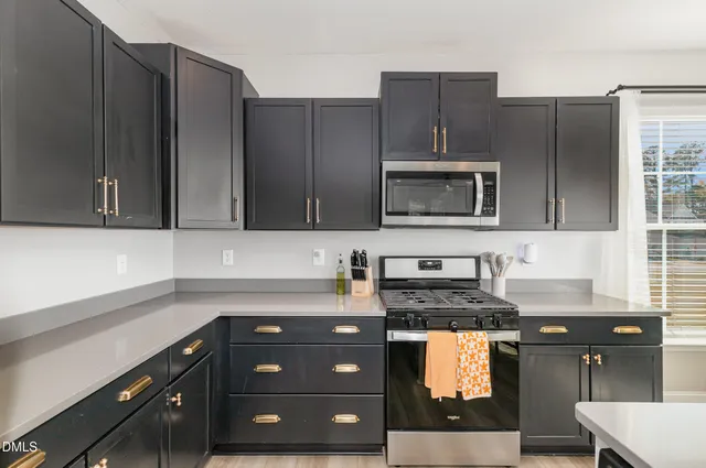 a kitchen with stainless steel appliances granite countertop a sink a stove and cabinets
