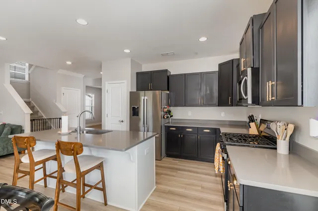a kitchen with stainless steel appliances granite countertop a refrigerator and a stove top oven