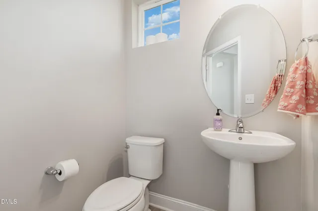 a bathroom with a sink toilet and a mirror