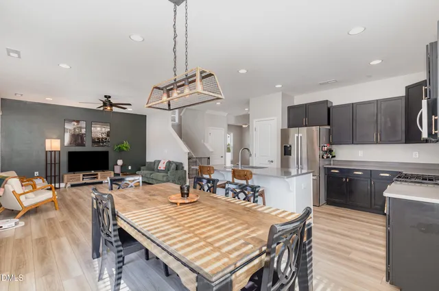 a kitchen with a table chairs stainless steel appliances and wooden floor