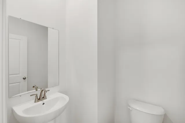 a bathroom with a sink a toilet and a mirror