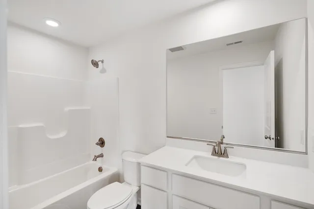 a bathroom with a sink vanity granite toilet tub and shower