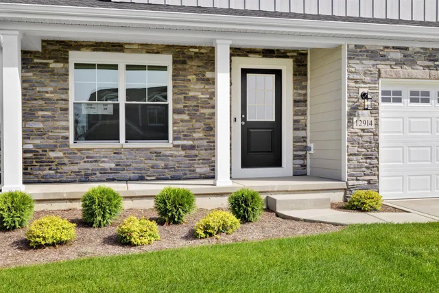 a front view of a house with a yard and outdoor seating