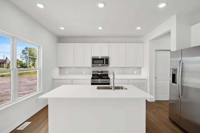 a kitchen with a stove a refrigerator and a sink