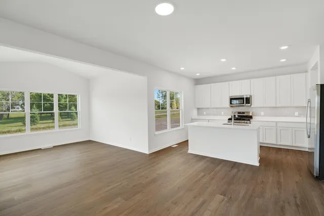 a kitchen with a refrigerator and white cabinets