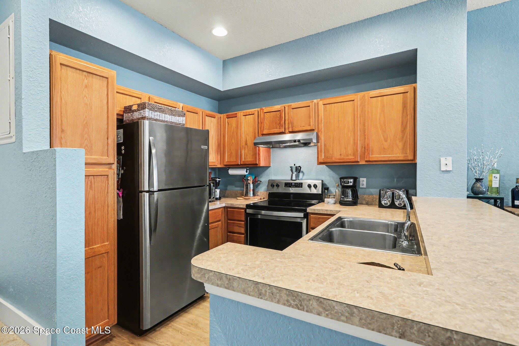 3955 Almeida Court, Unit 103 Melbourne, FL 32901 - Photo 11 of 32 a kitchen with a refrigerator and a sink