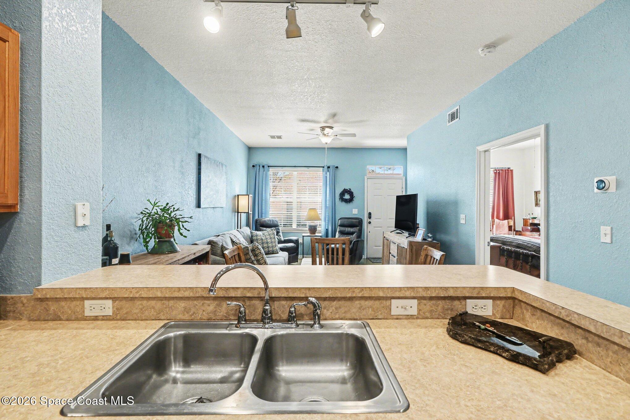 3955 Almeida Court, Unit 103 Melbourne, FL 32901 - Photo 12 of 32 a kitchen with a sink and a large mirror