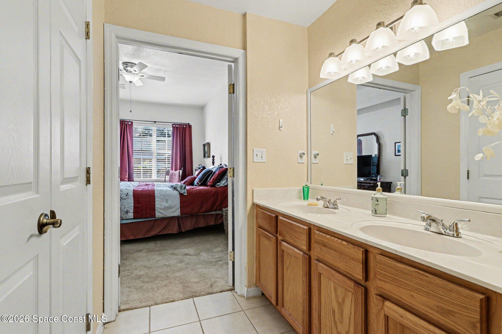 3955 Almeida Court, Unit 103 Melbourne, FL 32901 - Photo 17 of 32 a en suite bathroom with a tub sink and mirror
