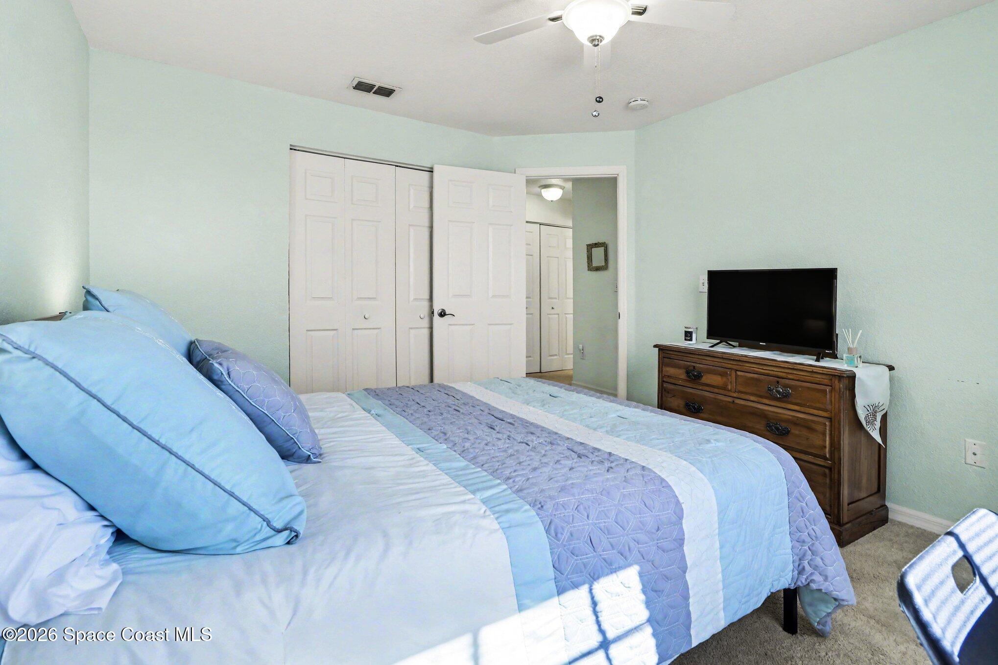 3955 Almeida Court, Unit 103 Melbourne, FL 32901 - Photo 21 of 32 a bedroom with a bed and a flat screen tv
