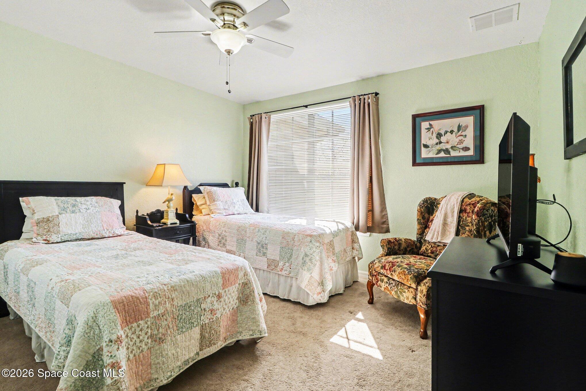 3955 Almeida Court, Unit 103 Melbourne, FL 32901 - Photo 22 of 32 a bedroom with two beds and a chandelier