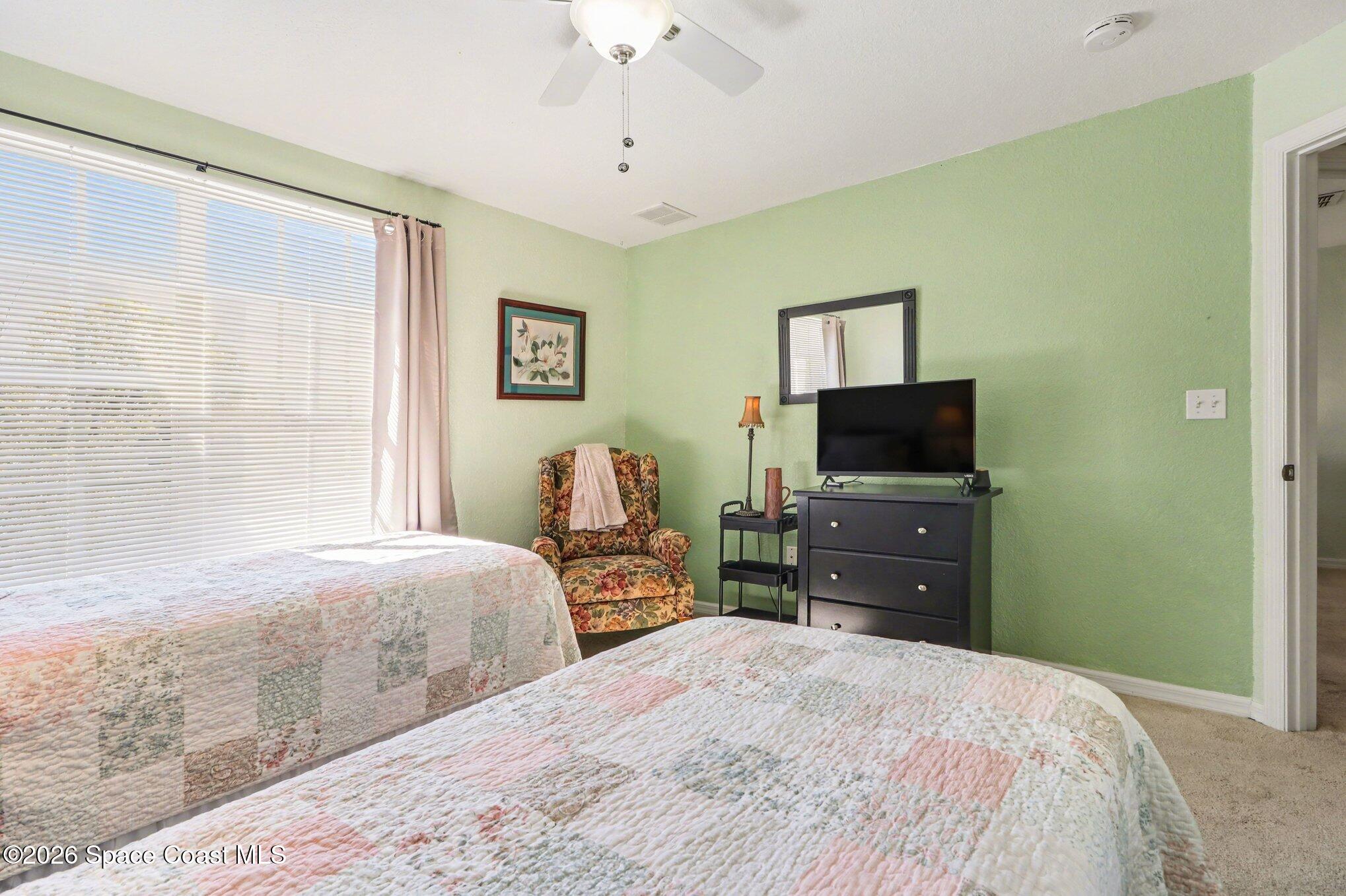 3955 Almeida Court, Unit 103 Melbourne, FL 32901 - Photo 23 of 32 a bedroom with a bed and a flat screen tv
