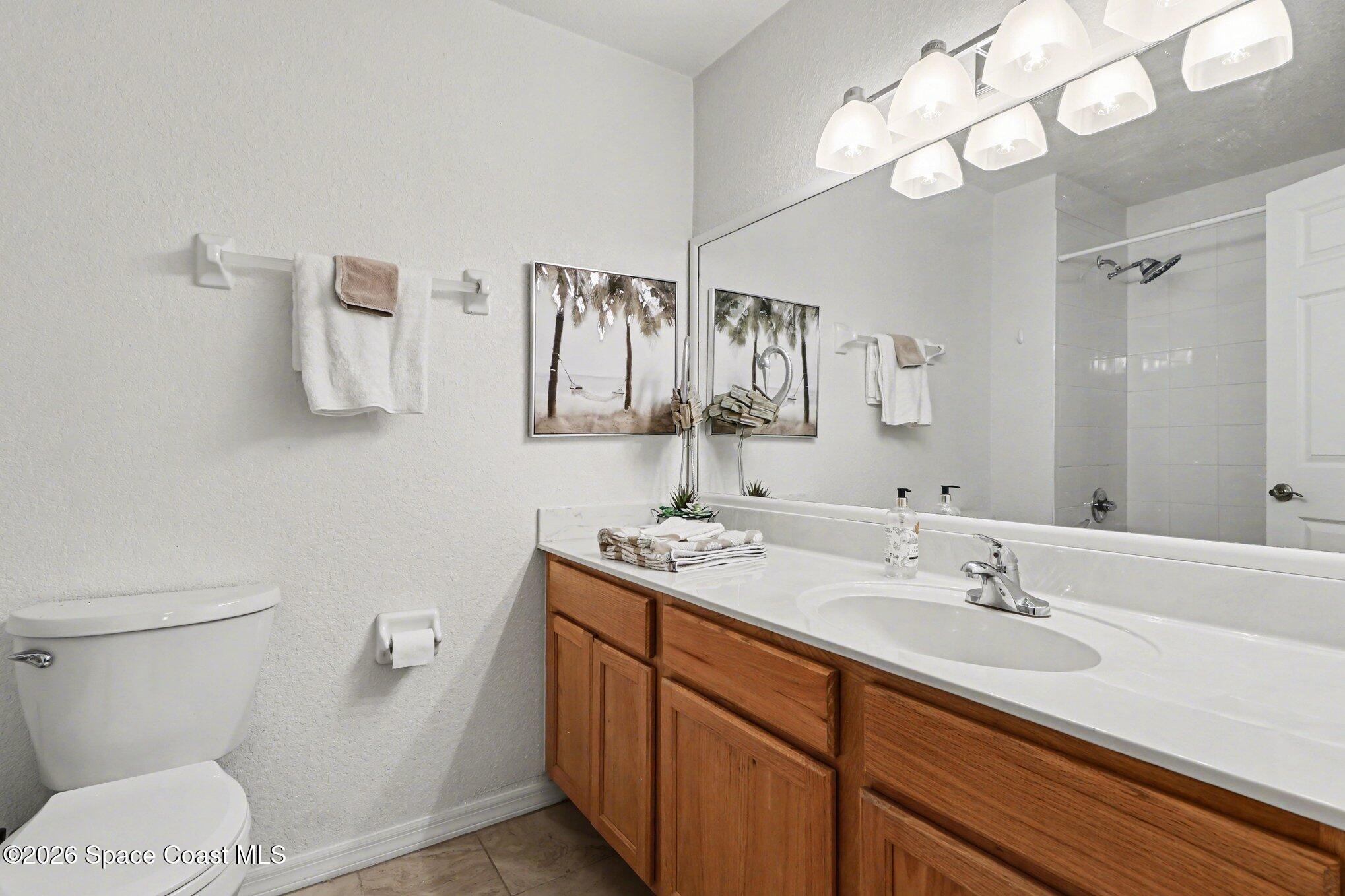 3955 Almeida Court, Unit 103 Melbourne, FL 32901 - Photo 24 of 32 a bathroom with a sink a toilet and a mirror