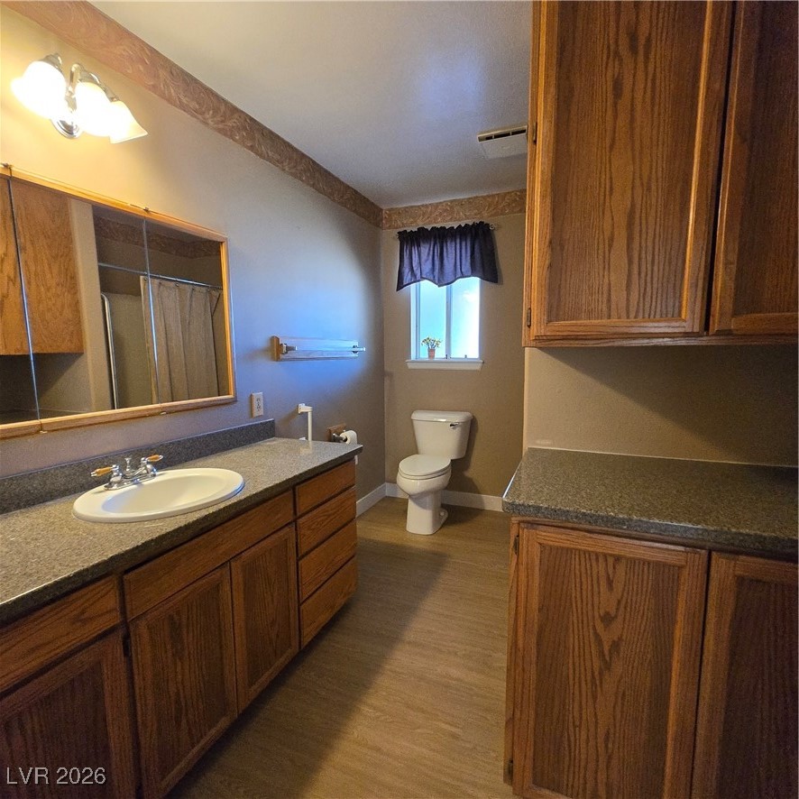 630 East Simkins Road Pahrump, NV 89060 - Photo 45 of 50 Full bath featuring a shower with curtain, vanity, and dark wood-style floors
