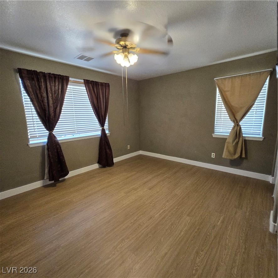 630 East Simkins Road Pahrump, NV 89060 - Photo 47 of 50 Empty room featuring a textured ceiling, ceiling fan, and wood finished floors
