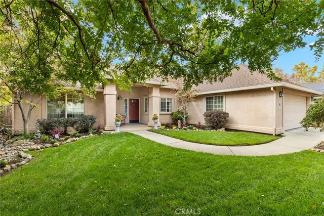 a front view of a house with a yard and trees
