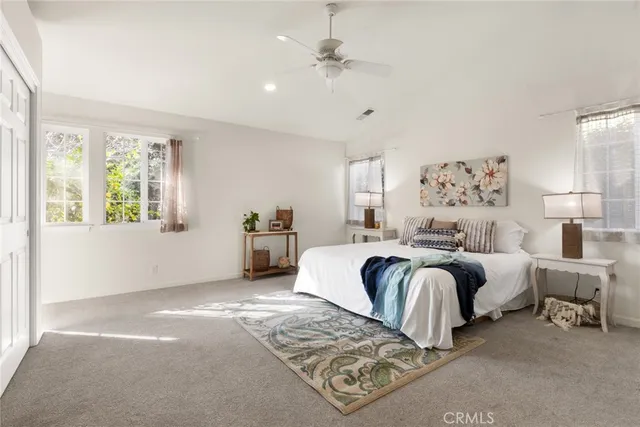 a bedroom with a large bed and a chandelier