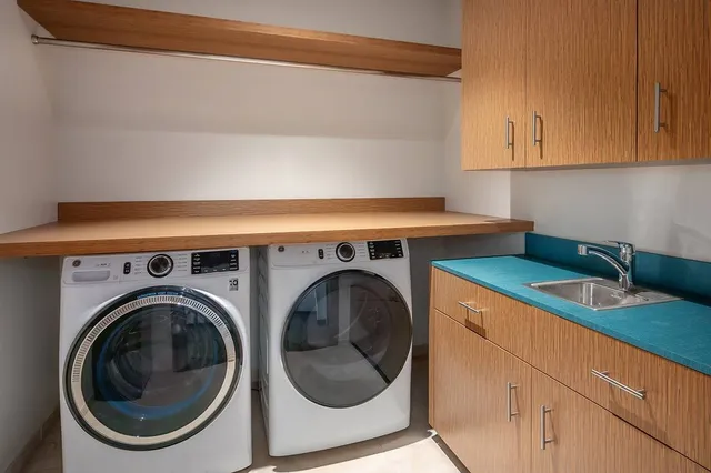 a utility room with sink dryer and washer