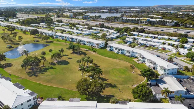 an empty room with wooden floor closet and windows