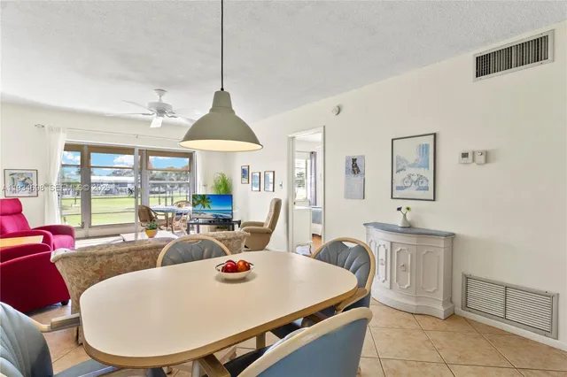 a very nice looking dining room with furniture a large window and a chandelier