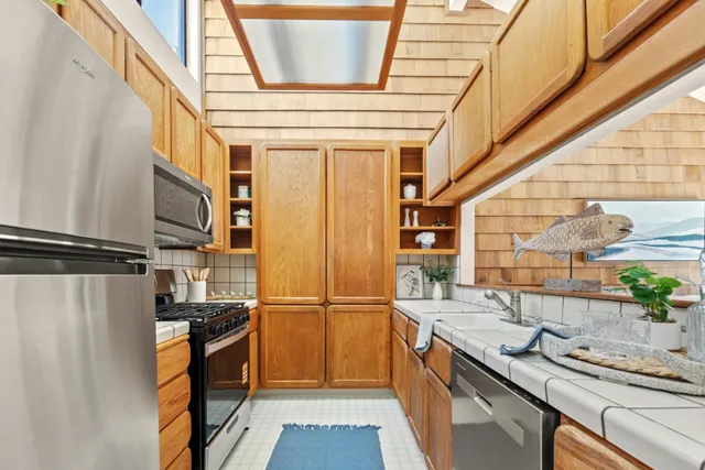 a kitchen with granite countertop a sink and a refrigerator