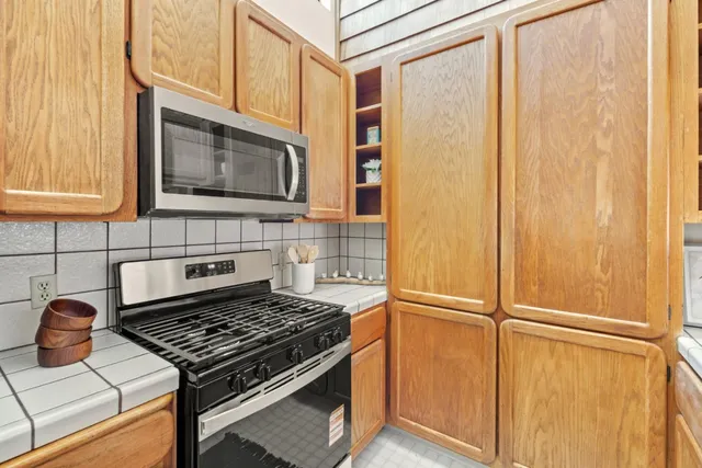 a stove top oven sitting inside of a kitchen