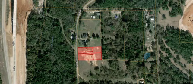 an aerial view of residential house with outdoor space and trees all around