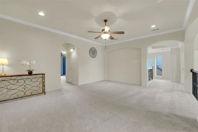 a view of a livingroom with a chandelier fan and wooden floor