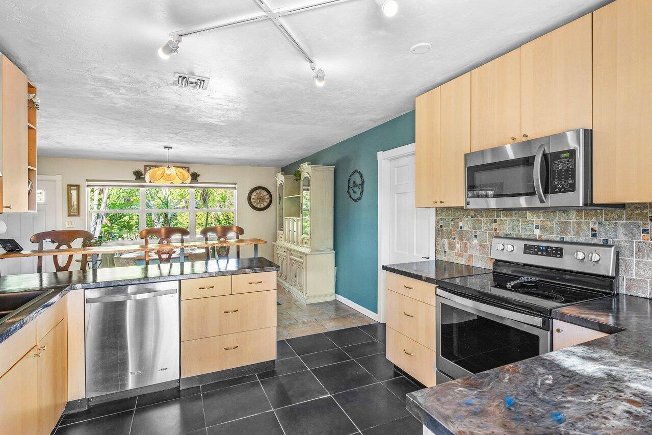 3064 Rostan Lane Palm Springs, FL 33461 - Photo 12 of 49 a kitchen with stainless steel appliances a stove sink and microwave