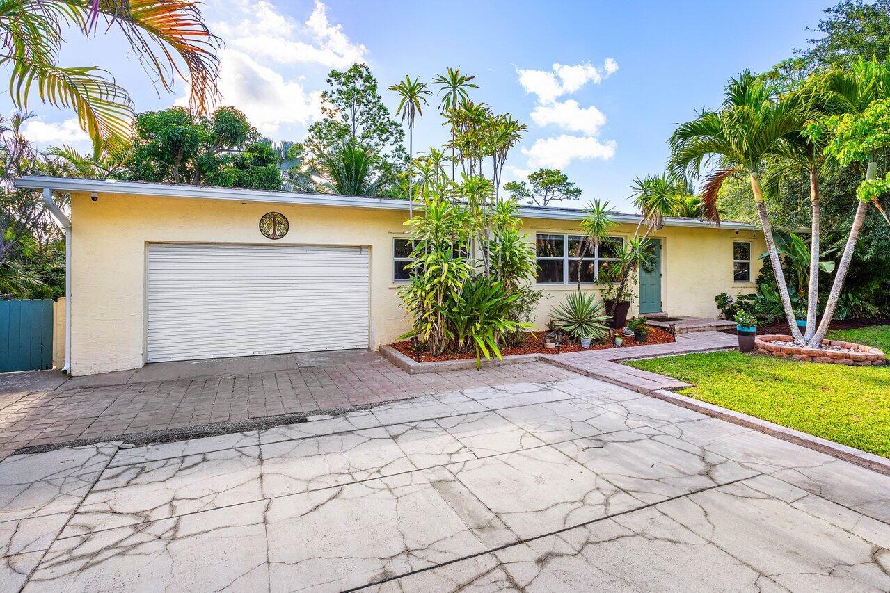 3064 Rostan Lane Palm Springs, FL 33461 - Photo 3 of 49 a front view of house with yard and trees around