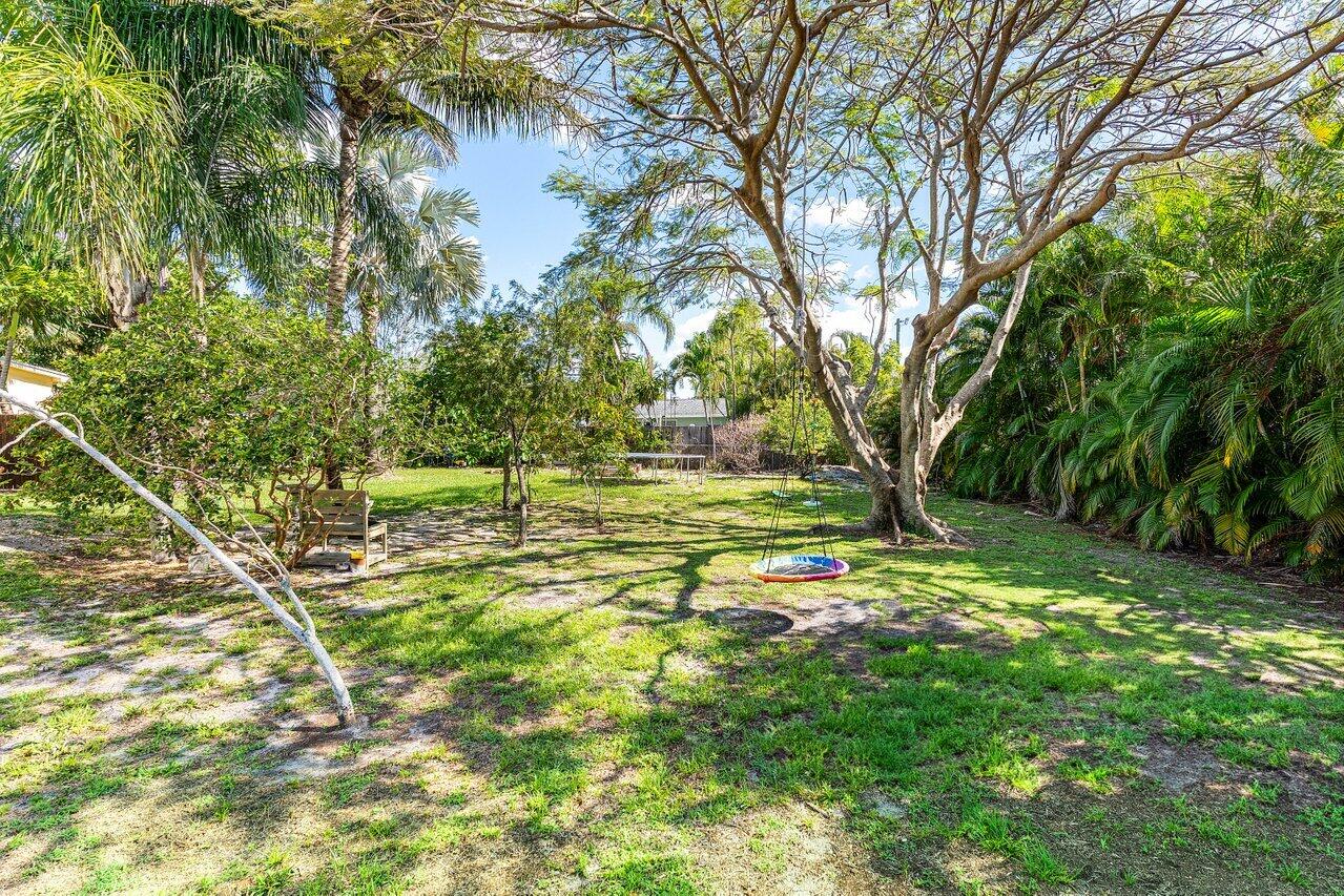 3064 Rostan Lane Palm Springs, FL 33461 - Photo 41 of 49 a backyard of a house with lots of green space and fountain
