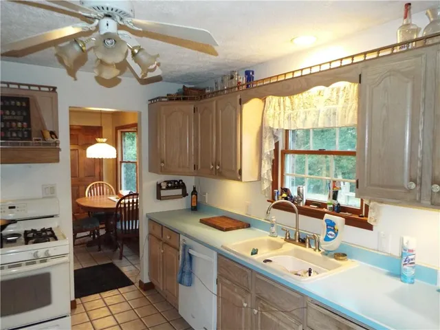 a kitchen with a sink a window cabinets and appliances
