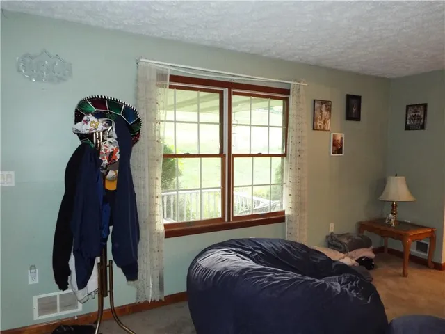 a bed sitting in a bedroom next to a window