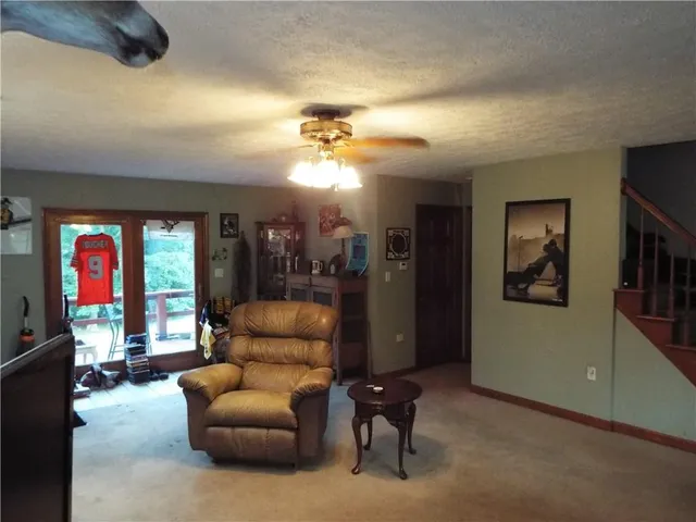 a living room with furniture and a ceiling fan