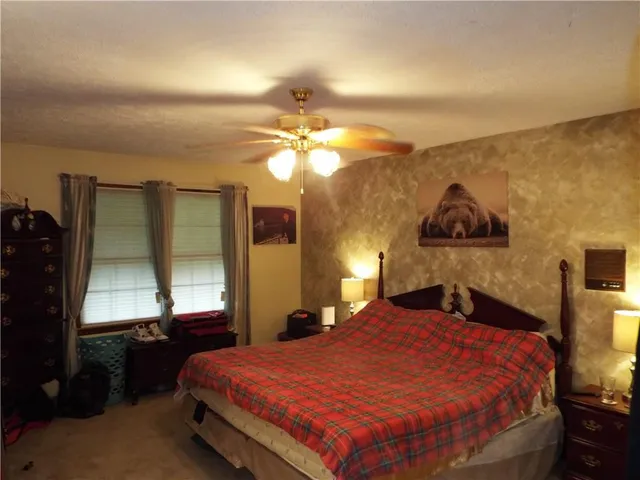 a bed sitting in a bedroom next to a window