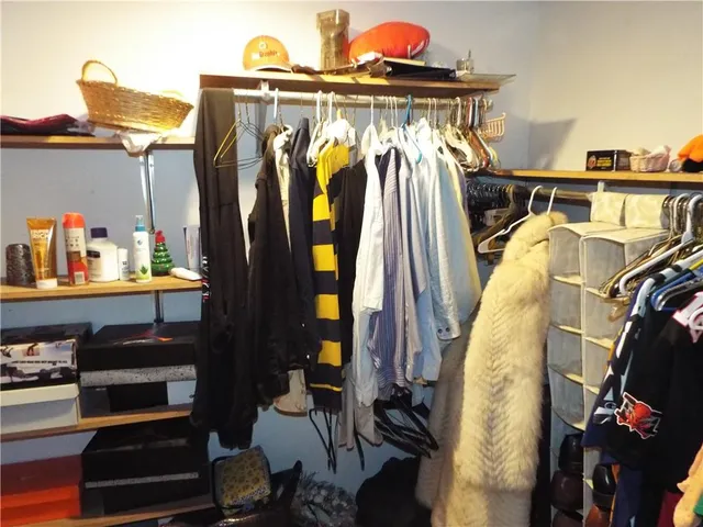 a view of walk in closet with clothes and shoes