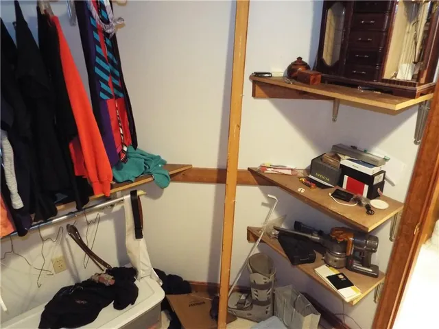 a view of walk in closet with clothes and shoes