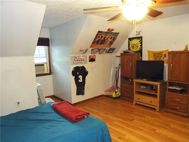 a room with gym equipment and wooden floor