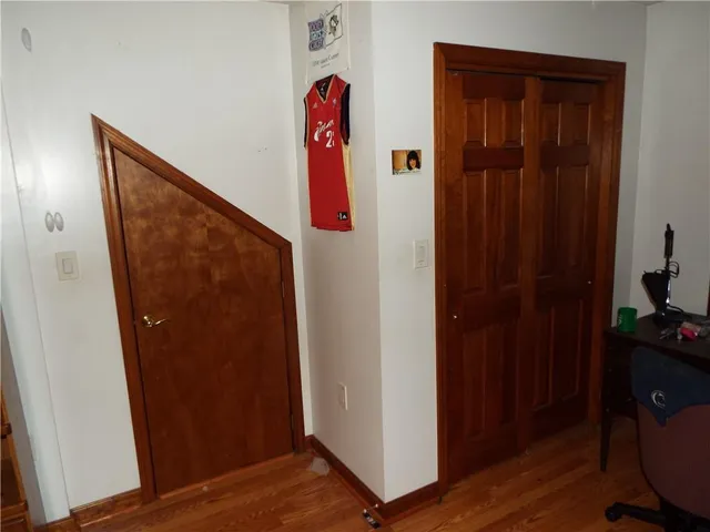 a view of a hallway with wooden floor and closet