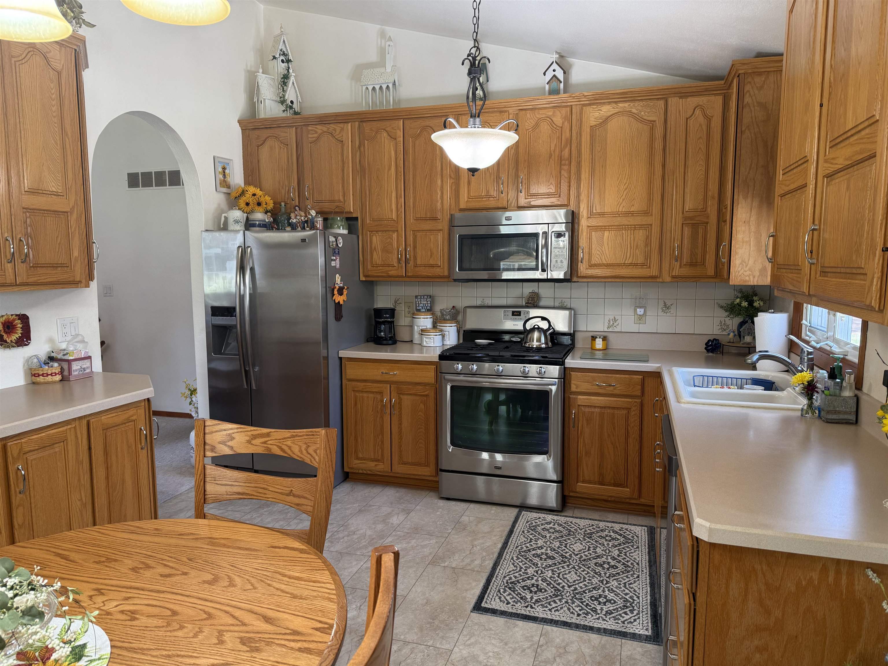 2822 Norway Pine Road Rockford, IL 61109 - Photo 4 of 18 a kitchen with stainless steel appliances granite countertop a sink a stove a refrigerator cabinets and living room view