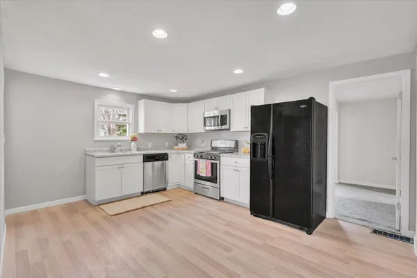 a kitchen with a refrigerator and white cabinets