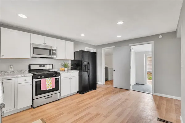 a kitchen with stainless steel appliances granite countertop a refrigerator a stove top oven a sink and dishwasher