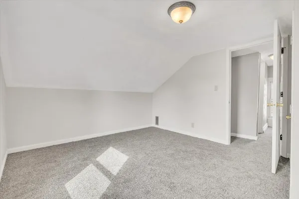 an empty room with a lamp and a window