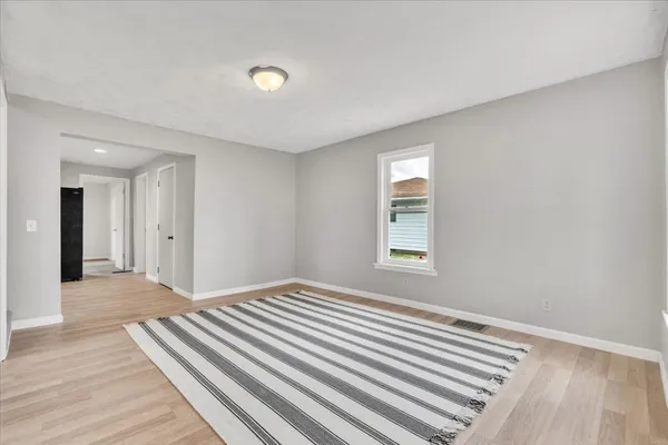 a view of a room with wooden floor and a window