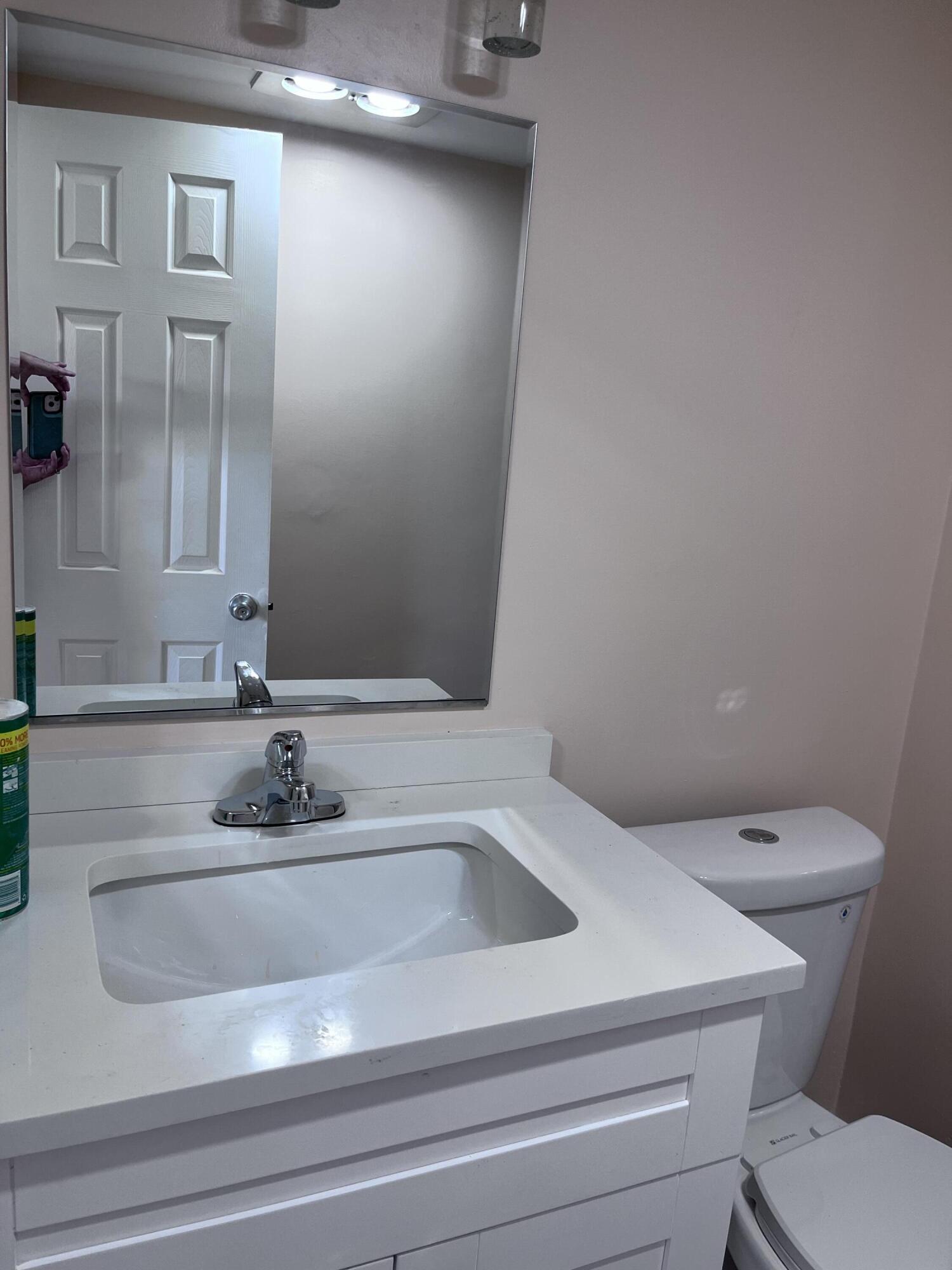 251 South Golf Boulevard, Unit 294 Pompano Beach, FL 33064 - Photo 18 of 36 a bathroom with a sink and mirror